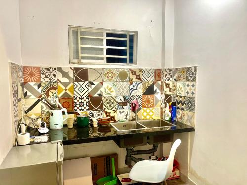 een keuken met een wastafel en een aanrecht met tegels bij Enjoy Homestay in Ho Chi Minh-stad