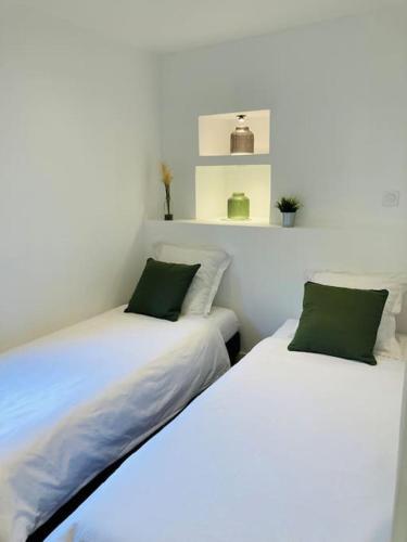 deux lits côte à côte dans une pièce dans l'établissement L'écrin de Chapoulier, à Montoison