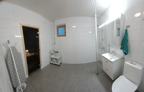 La salle de bains blanche est pourvue de toilettes et d'un lavabo. dans l'établissement Family apartment Hämeenlinna with SAUNA, à Hämeenlinna