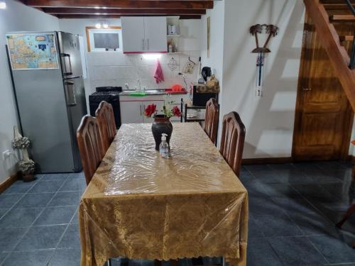 uma cozinha com uma mesa com um vaso sobre ela em Cabaña Ceferino Ushuaia em Ushuaia
