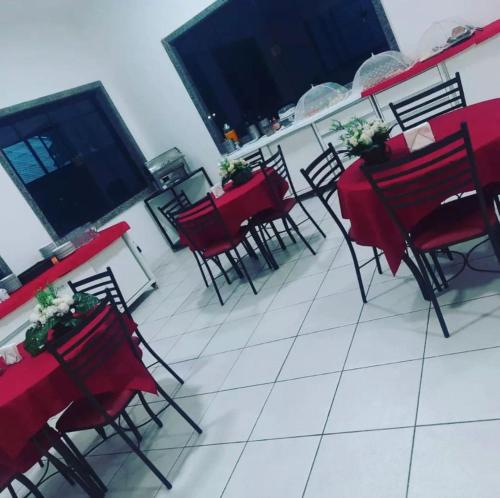 een groep rode tafels en stoelen op een patio bij Versatile Park Hotel in Ponta Porã