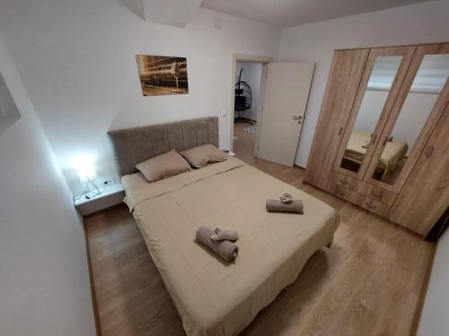a bedroom with a large bed with two towels on it at Apartman Muzika Jagodina in Jagodina