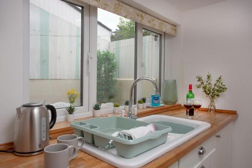 a kitchen counter with a sink and a window at Cheddar Cottage in Sidmouth