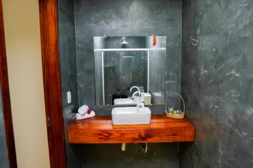 a bathroom with a sink and a mirror at POUSADA VILLAGE KITE in Camocim