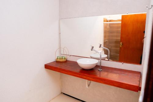 a bathroom with a sink and a mirror at POUSADA VILLAGE KITE in Camocim