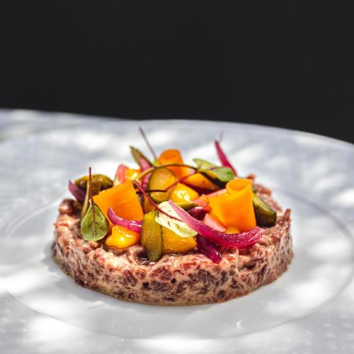 a piece of bread with vegetables on a plate at Le Boeuf Couronné - Hôtel & Restaurant Chartres- Logis Hotels in Chartres