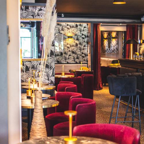a restaurant with red chairs and tables in a room at Le Boeuf Couronné - Hôtel & Restaurant Chartres- Logis Hotels in Chartres