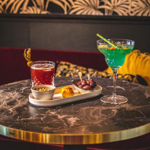 a table with a plate of food and a drink at Le Boeuf Couronné - Hôtel & Restaurant Chartres- Logis Hotels in Chartres