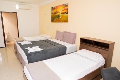 um quarto com duas camas e um quadro na parede em POUSADA VILLAGE KITE em Camocim