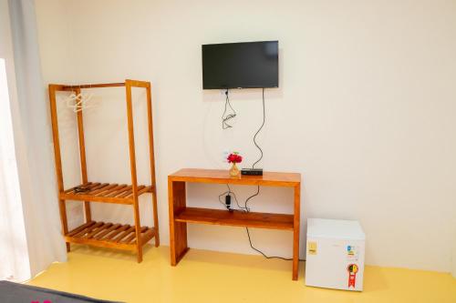 a room with a television on a wall with a table at POUSADA VILLAGE KITE in Camocim