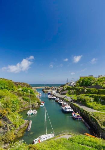 a group of boats are docked in a river at Converted Welsh Sunday School with Sea View & Garden on Anglesey - Dog Friendly in Amlwch