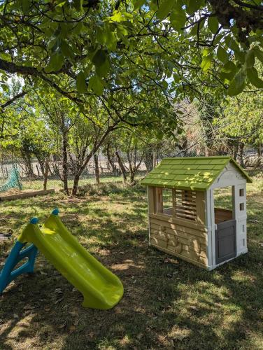 un parque infantil con tobogán y una casa de juegos en Gite de campagne avec SPA privatif, en Saint-Sauvant