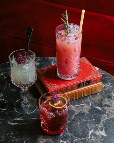 a table topped with two cocktails and two books at Le Boeuf Couronné - Hôtel & Restaurant Chartres- Logis Hotels in Chartres