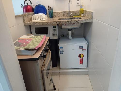 cocina pequeña con fregadero y nevera pequeña en Apartamento Rio, en Río de Janeiro