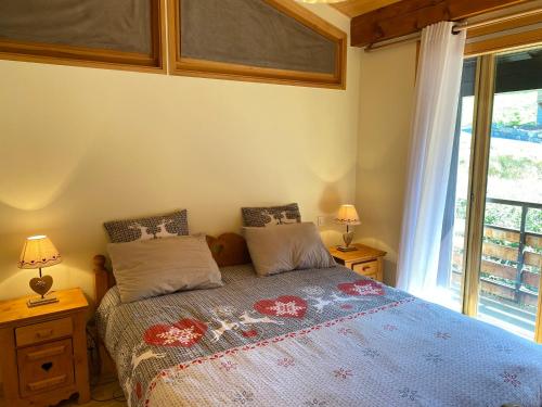 une chambre avec un lit avec deux lampes et une fenêtre dans l'établissement Location aux Gets : Appt 3* pour 6 pers, proche centre et pistes, WiFi, parking, casier à skis - FR-1-623-343, aux Gets