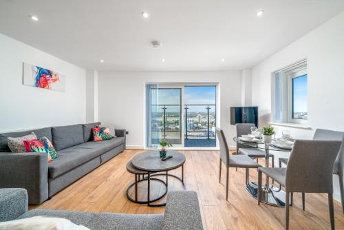a living room with a couch and a table at Skyvillion - London River Thames Top Floor Apartments by Woolwich Ferry, Mins to London ExCel, O2 Arena , London City Airport with Parking in London