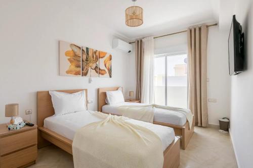 a hotel room with two beds and a window at Chic Apart Spacieuse & Lumineuse in Tangier