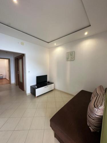a living room with a tv on a white wall at Apartments Alać in Drasnice