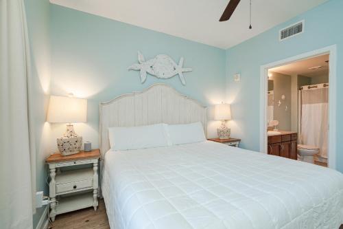 1 dormitorio con 1 cama blanca grande y 2 mesitas de noche en Laketown Wharf #119 by Nautical Properties, en Panama City Beach