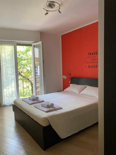 a bedroom with a bed with a red wall at Casa Lavanda in Torri del Benaco