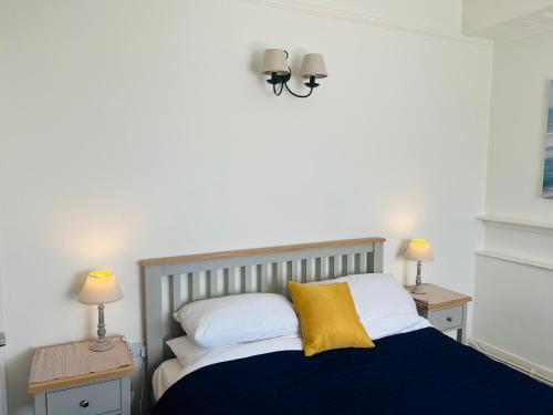 a bedroom with a bed with two night stands and two lamps at High Tides in Lyme Regis