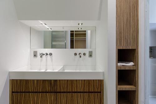 ein Bad mit einem Waschbecken und einem Spiegel in der Unterkunft My Stay Brussels - Couronne in Brüssel