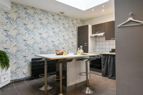 a kitchen with a table and a blue and white wallpaper at T2 - parking et jardin privatif in Lambersart
