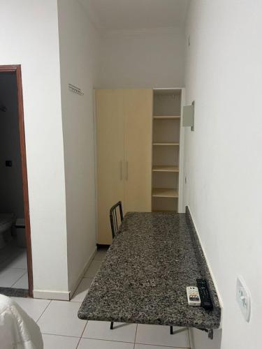 an empty room with a table and a closet at Versatile Park Hotel in Ponta Porã