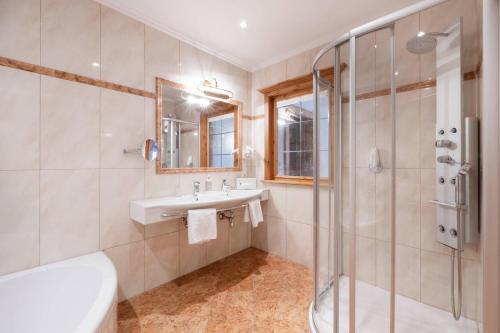 a bathroom with a sink and a shower at Hotel Stubaierhof in Neustift im Stubaital