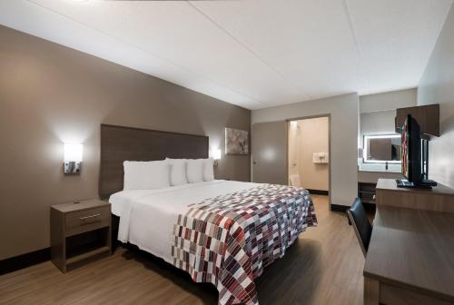 Habitación de hotel con cama y TV de pantalla plana. en Red Roof Inn Chattanooga Airport, en Chattanooga