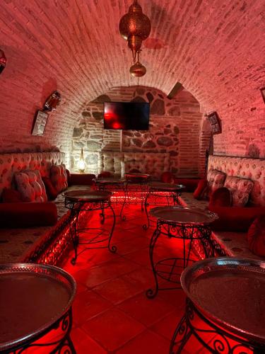 a room with tables and couches in a brick wall at Entre Dos Aguas Hotel Boutique in Toledo