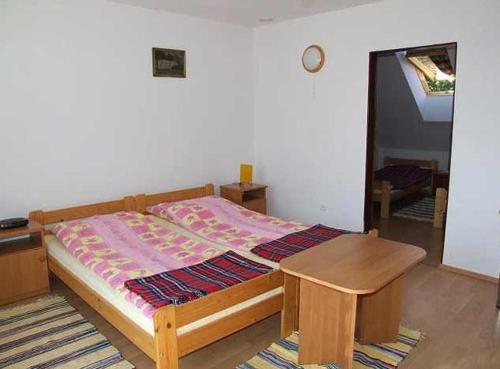 a bedroom with a bed and a wooden table at Pokoje Gościnne POD KNOTEM in Karwieńskie Błoto Drugie