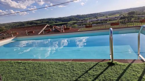 a large blue swimming pool with a view of a mountain at Villa Bordone in Villafranca dʼAsti