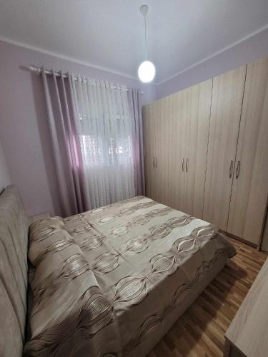 een slaapkamer met een groot bed en een raam bij Family Oasis in Vlorë