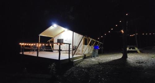 duży biały namiot z oświetleniem w ciemności w obiekcie Charming enclave Luxury tent in the woods Tent 3 Bambi's playground w mieście Lenoir
