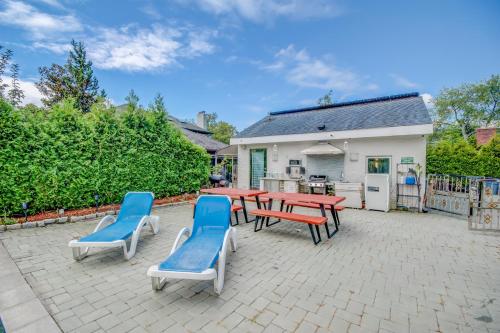a patio with picnic tables and blue chairs at GABLES new 2024 in Bayside