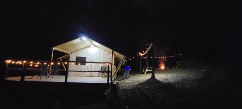 勒諾的住宿－Charming enclave Luxury tent in the woods Tent 3 Bambi's playground，黑暗中灯的白色帐篷