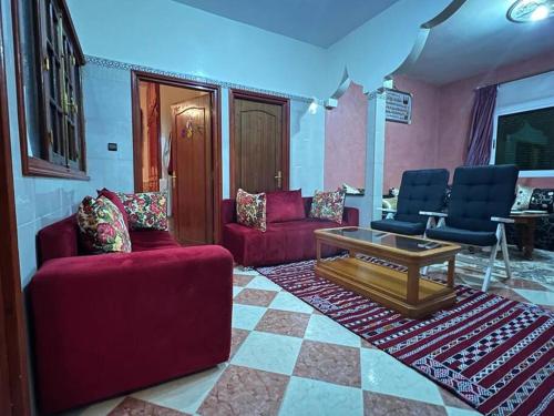 a living room with two red couches and a coffee table at Pearl in the Middle Atlas - ground floor in Azrou