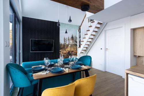 jadalnia ze stołem i niebieskimi krzesłami w obiekcie Cichosfera- Dom w Dusznikach-Zdrój w mieście Duszniki Zdrój