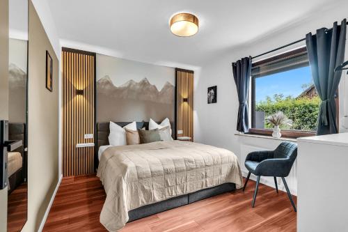 a bedroom with a bed and a window and a chair at STANMA Luchspartment ruhig und zentral mit großem Balkon und Parkplatz in Braunlage