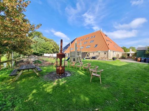 a group of chairs sitting in the grass next to a building at Verblijf bij Bynt in Sneek