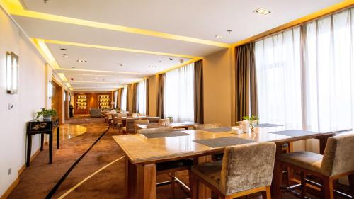 a restaurant with tables and chairs and large windows at Holiday Inn Mudanjiang by IHG in Mudanjiang
