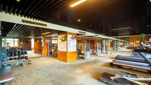 a gym with a lot of treadmills and machines at Holiday Inn Mudanjiang by IHG in Mudanjiang