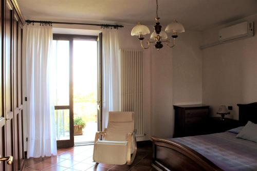 1 dormitorio con 1 cama, 1 silla y 1 ventana en Room in Guest room - La Culla Tra I Vigneti - Stanza, en Grazzano Badoglio