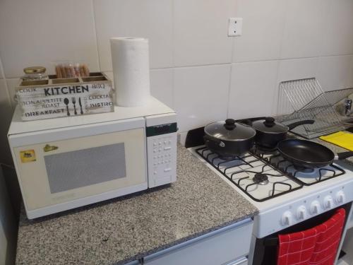 uma cozinha com um fogão com panelas e frigideiras em NEW YORK EN EDIFICIO MAFALFA COCHERA y Asador INCLUIDA em Río Cuarto