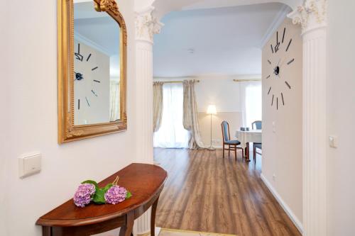 - un salon avec une table et un miroir dans l'établissement VIP Apartment Baden-Baden, à Baden-Baden