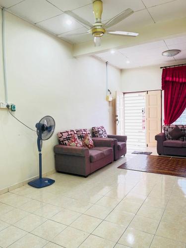 a living room with a couch and a fan at Sofea Homestay Ipoh in Ipoh