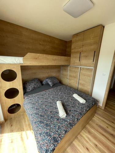 a bedroom with a bed with two remotes on it at Apartmán Skis in Černá v Pošumaví