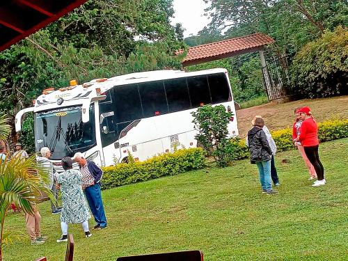a group of people standing in the grass near a food truck at Hotel Kasama in San Agustín