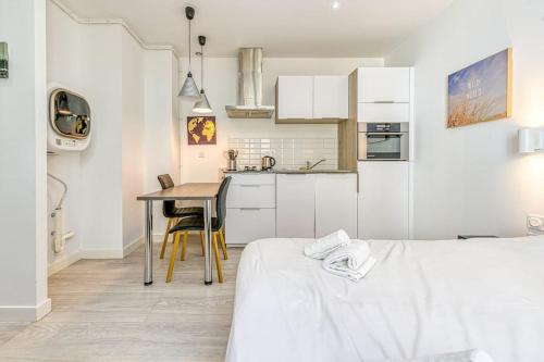 - une cuisine blanche avec une table dans une pièce dans l'établissement 44 Foch 3, à Grenoble